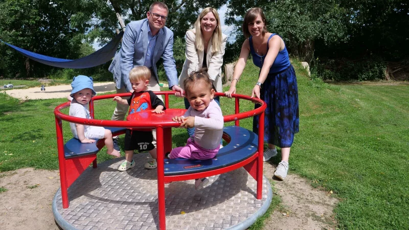 Bei der symbolischen Übergabe des neuen Kinderkarussells: Björn Hartmann (Leiter Bereich Personal Brasseler), Laura Fuchs (Unternehmenskommunikation Brasseler) und Angelina Eichmann (ständige Vertretung der Dorfleitung Westfälisches Kinderdorf, von links) – gemeinsam mit Kindern aus dem Kinderdorf. - © Westfälisches Kinderdorf