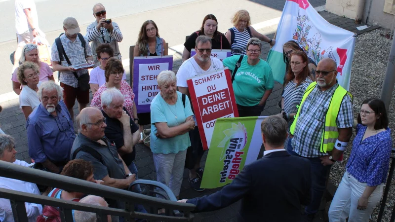 Rechtsanwalt Gerhard Ihle erkl&auml;rt den Demonstranten im Juni 2024 vor dem Arbeitsgericht in Detmold rund um die Gewerkschaft Verdi, was im Sitzungssaal besprochen wurde. Kurz danach gab es die erste Niederlage. - &copy; Janet K&ouml;nig