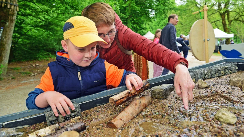 Theodor und Mama Sabrina gestalten am Stand des Projektes „Wasser im Fluss“ den Wasserlauf in einem kleinen Flussbett. - © Nicole Ellerbrake