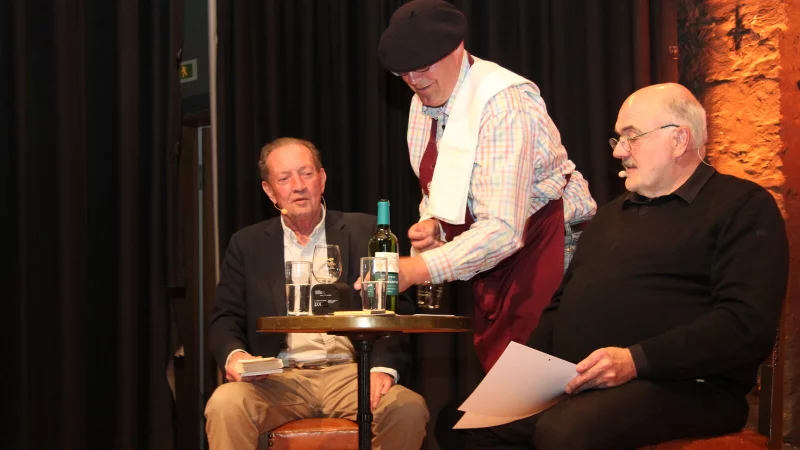 Lesen mit trockener Kehle ist weder was für Martin Walker (links), noch für Joachim H. Peters. Darum lassen sich die beiden Krimiautoren im Kulturhaus Alte Meierei erst mal von Pierre-Louis Plat einen einschenken. - © Marianne Schwarzer