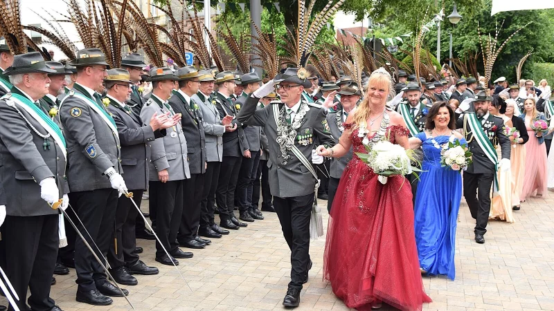 Das Königspaar Thorsten Linnenlüke und Sandra Vortmann-Schreiber schreitet, gefolgt vom Bierkönigspaar und der Throngemeinschaft, die Reihen der Schützen auf dem Rathausplatz ab. - © Karin Prignitz