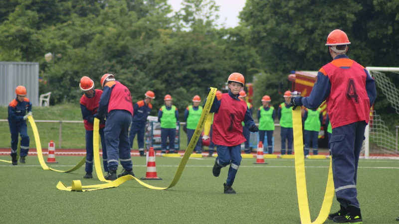Die Jugendlichen müssen die Feuerwehrschläuche aneinander kuppeln. - © Daniel Hobein