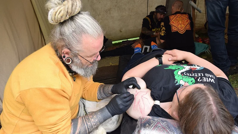 Lars Martinen aus Kopenhagen tätowiert Natalie Müller aus Castrop-Rauxel das begehrte Motiv eines Raben auf den linken Oberarm. Damit sind beide einige Stunden beschäftigt. - © Karin Prignitz