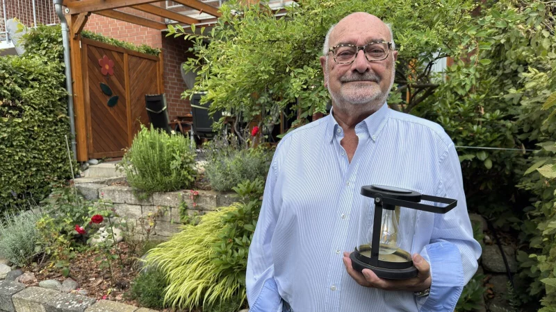 Eduard B&ouml;ger in seinem Garten. In der Hand h&auml;lt er eine solarbetriebene Gartenlampe, die sich bei Dunkelheit automatisch einschaltet. Die nachhaltige Stromerzeugung ist ihm ein Anliegen. - &copy; Sven Kienscherf