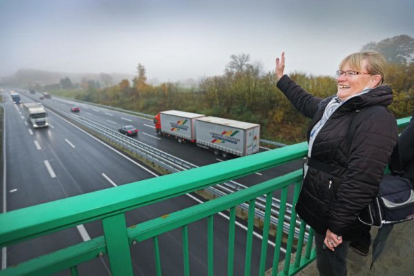 Ulrike Wegner, die eigens aus Detmold nach Borgholzhausen gekommen ist, winkt den ersten Fahrzeugen zu. - © Sarah Jonek