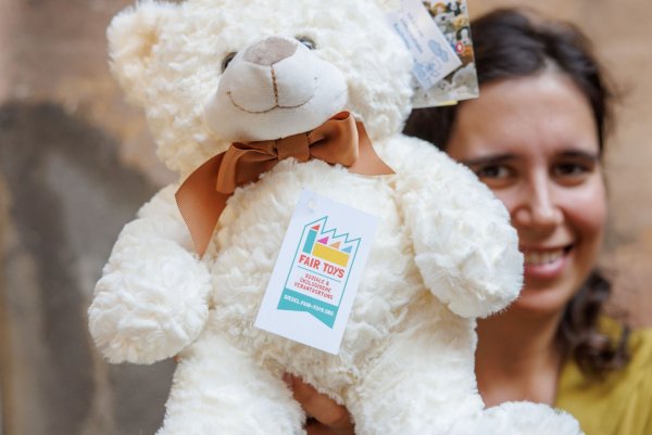 Eine Mitarbeiterin des Plüschtierherstellers Heunec präsentiert einen Stoffteddy, der mit dem Siegel der Fair Toys Organisation gekennzeichnet ist. - © Daniel Karmann/dpa