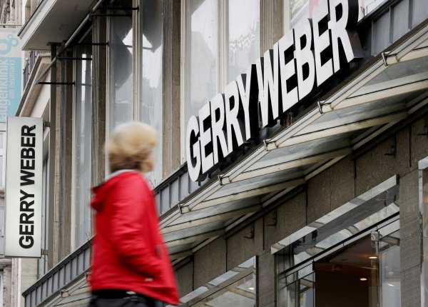 Eine Passantin vor einer Filiale des Modeherstellers Gerry Weber in Köln: Der Modeherstaeeler will zurück aus Kurs. - © Oliver Berg/dpa