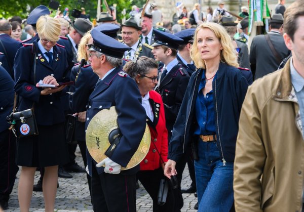 Die Schauspielerin Maria Furtwängler steht bei Dreharbeiten für einen neuen fiktiven „Tatort“ inmitten des realen Schützenausmarsches am Neuen Rathaus. - © Julian Stratenschulte/dpa