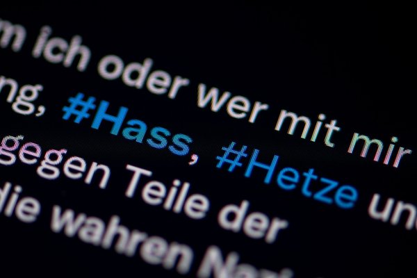 Auf dem Bildschirm eines Smartphones sieht man die Hashtags Hass und Hetze in einem Twitter-Post. - © Fabian Sommer/dpa