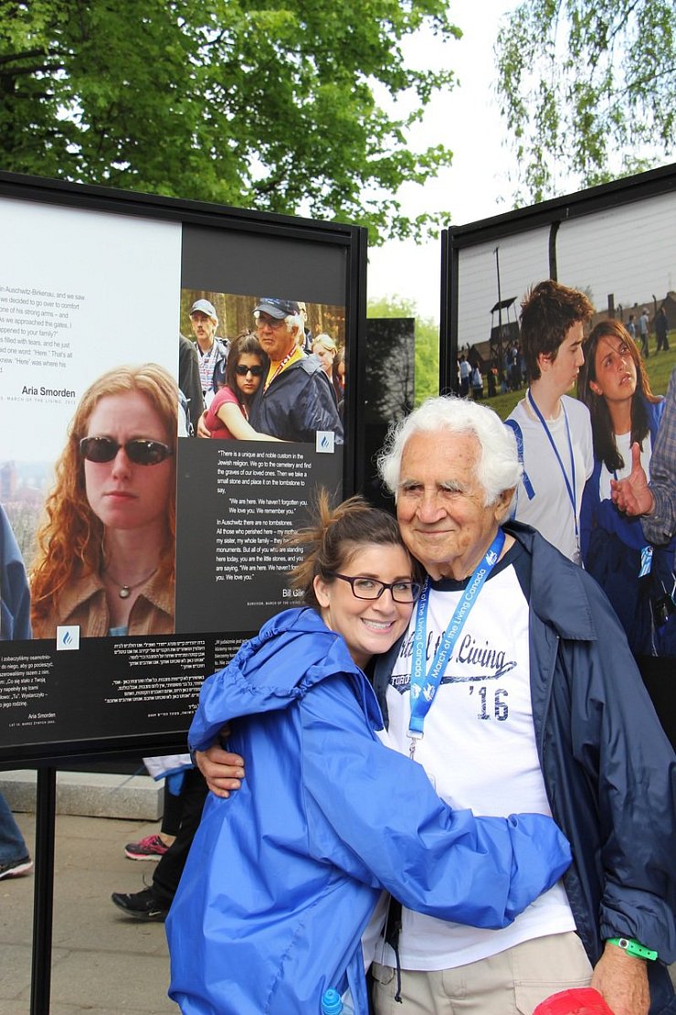 Auschwitz-Besuch 2016: Samantha steht mit ihrem Großvater Bill Glied im Mai vor der Ausstellungswand mit einem Foto, das die beiden zehn Jahre zuvor an selber Stelle zeigt. - © privat