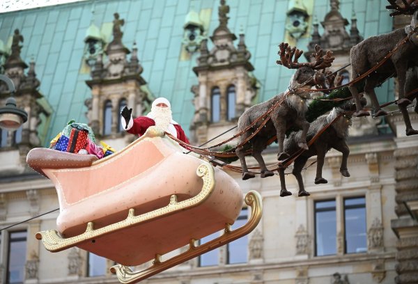 In Hamburg flog der Weihnachtsmann in einem Rentierschlitten über den Markt vor dem Rathaus. - © Niklas Graeber/dpa