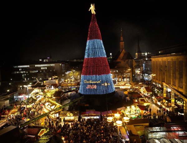 Die Beleuchtung des riesigen Weihnachtsbaums auf dem Dortmunder Weihnachtsmarkt wird eingeschaltet. - © Dieter Menne/dpa
