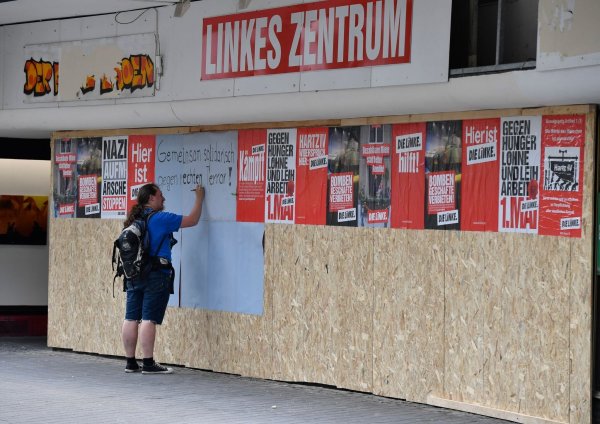 Ein Mann trägt sich am zerstörten Parteibüro der «Linke» in eine Unterschriftenliste ein. - © Roberto Pfeil/dpa/Archivbild