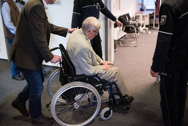 Der frühere Auschwitz-Wachmann Reinhold Hanning wird in einer Verhandlungspause im Rollstuhl in ein Besprechungszimmer geschoben. - © dpa