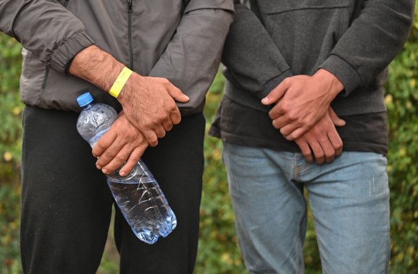 Unerlaubt eingereiste Migranten stehen am Straßenrand, nachdem sie durch die Bundespolizei aufgegriffen wurden. - © Patrick Pleul/dpa