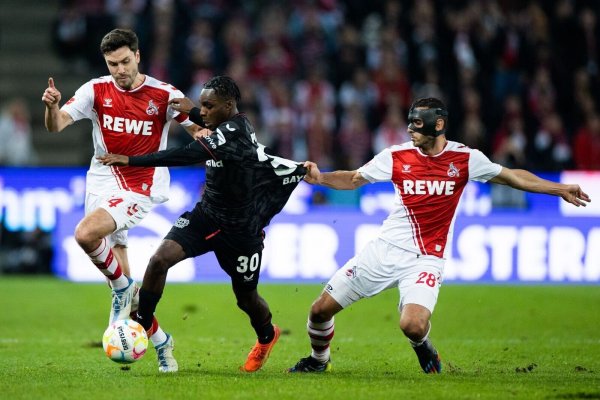 Kölns Jonas Hector (l) und Ellyes Skhiri (r) und Leverkusens Jeremie Frimpong versuchen an den Ball zu kommen. - © Rolf Vennenbernd/dpa