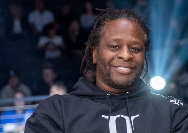 Der Moderator Mola Adebisi lächelt beim Event "Beat & Box". - © Marco Steinbrenner/dpa/Archivbild