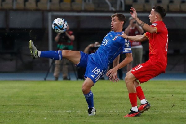 Italiens Nicolo Barella (l) und Jani Atanasov aus Nordmazedonien kämpfen um den Ball. - © Boris Grdanoski/AP/dpa