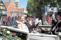 Grüßen aus der Kutsche das Volk: (von links) Königin Iris Becker, König Dieter Kratz und Königsoffizier Ernst Michael Lewecke beim Festumzug. - © Foto: Reineke