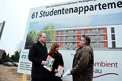 (von links) Tobias Krumsiek und Baufinanzierungsberaterin Wenke Holzgrewe diskutieren mit Projektentwickler Marco Mikli&szlig;. Im Hintergrund ist die Architektur der neuen Studentenappartements zu erkennen. - &copy; Foto: Reineke
