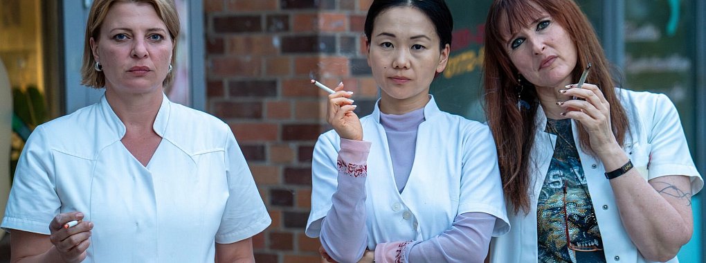 Das Team der «Beauty Oase Marzahn» aus der ARD-Serie «Marzahn Mon Amour» mit Chefin Jenny (Yvonne Yung Hee Bormann, Mitte) sowie den Angestellten Kathi (Jördis Triebel) und Lulu (Deborah Kaufmann). - © Oliver Vaccaro/ARD Degeto Fim/UFA Fiction GmbH/dpa