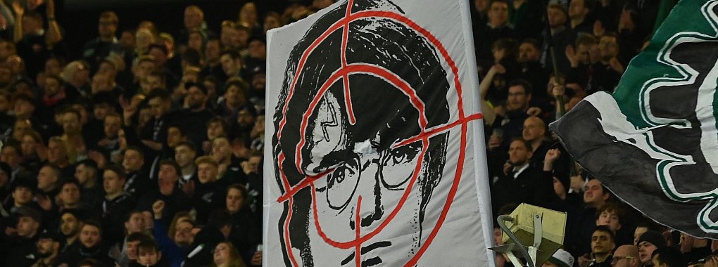 Hannover-Fans halten ein Fadenkreuz-Plakat mit dem Gesicht des Film-Zauberers Harry Potter hoch. - &copy; Swen Pf&ouml;rtner/dpa