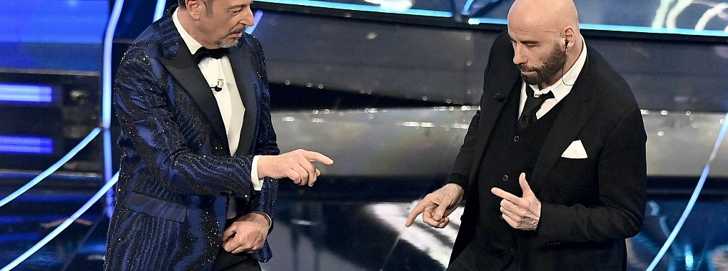 John Travolta (r) und Amadeus treten während des Sanremo-Musikfestivals auf. - © Marco Alpozzi/LaPresse/AP