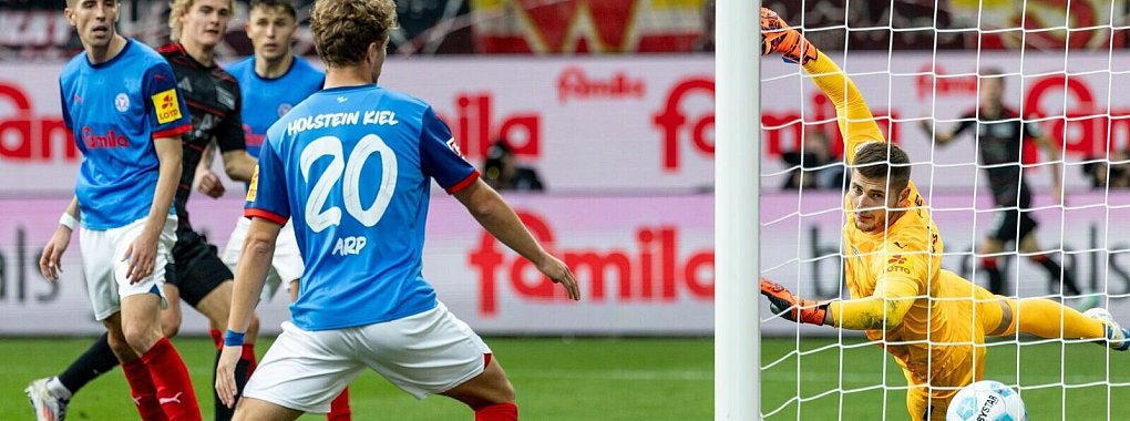 Union Berlins Tom Rothe (2. v l) trifft zum 0:2 gegen Kiels Torwart Timon Weiner (r). - © Axel Heimken/dpa