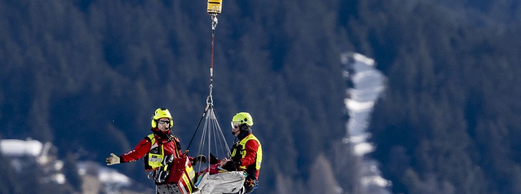 Nils Alphand wird nach seinem Sturz in Crans-Montana abtransportiert. - © Jean-Christophe Bott/KEYSTONE/dpa