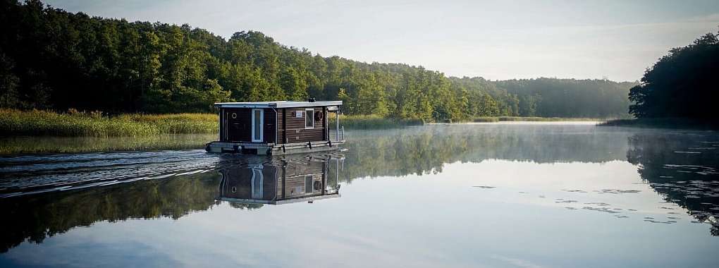 Schönes Revier in Brandenburg: Ein Hausboot fährt am frühen Morgen im Sonnenschein über die Havel. - © Kay Nietfeld/dpa/dpa-tmn