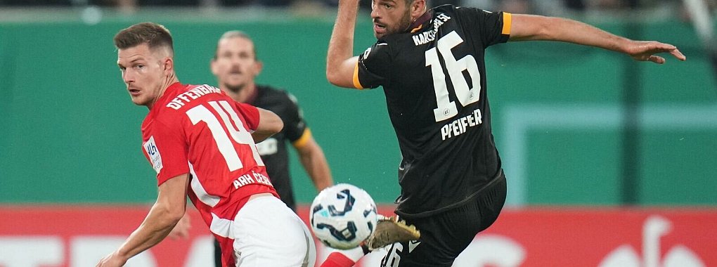 Der Karlsruher SC um Luca Pfeiffer (r) setzte sich im DFB-Pokal gegen die Kickers Offenbach um Kristjan Arh Cesen durch. - © Thomas Frey/dpa