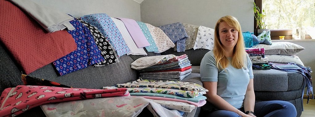 Franzsika Berghahn aus Bad Meinberg hat ihr Sofa in ein Stofflager umfunktioniert. Vor und nach der Arbeit näht die Rettungsassistentin Behelfsmasken und verkauft sie über ihren Online-Shop. - © Franziska Berghahn