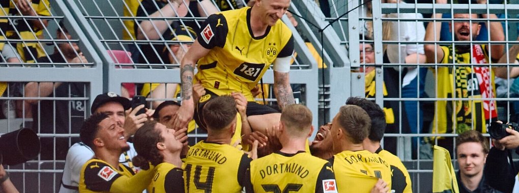 Die Dortmunder Spieler bejubeln mit Marco Reus sein Tor zum 2:0. - &copy; Bernd Thissen/dpa