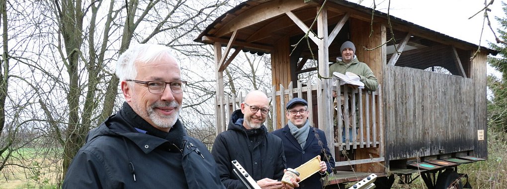Klaus Bamberger (von links), Guido Letmathe, Michael Meese und Sven Lohöfener stellen die technische Idee am Bauwagen von Sven Lohöfener vor. Hier hält er einen Teil seiner Bienenvölker. - © Alexandra Schaller