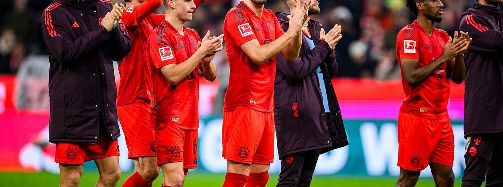 Die Bayern, in der Mitte der zweifache Torschütze Harry Kane, feiern das 3:0 gegen Union Berlin vor der Fankurve. - © Tom Weller/dpa