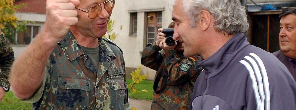 DFB-Teamchef Rudi Völler (r) wird beim Besuch bei den deutschen Soldaten der SFOR-Truppe im Feldlager Raijlovac in Sarajevo von Oberst Gerhard Stelz begrüßt. - © Achim Scheidemann/dpa
