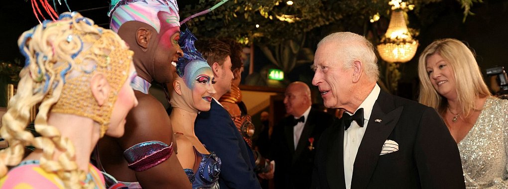 Charles begrüßt Künstler bei seinem Besuch der Royal Variety Performance. Laut PA konnte sich der König ein Lächeln über den Witz eines Trump-Imitators nicht verkneifen. - © Hollie Adams/Pool Reuters/AP