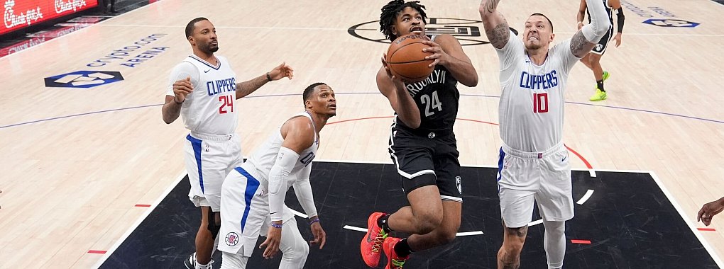 Nets-Guard Cam Thomas (24) zieht an Clippers-Center Daniel Theis (10) vorbei zum Korb. - © Marcio Jose Sanchez/AP