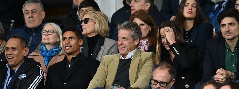 Proninenz auf der Tribüne: Hollywood-Star Hugh Grant (Mitte) im Stadion von Como 1907. - © ---/Verein Como 1907/dpa