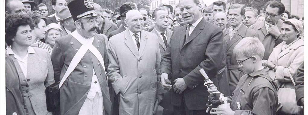 Willy Brandt (Bildmitte) ist noch Berlins Bürgermeister, als er am 20. Juni 1966 vor die Detmolder tritt. Begleitet wird der SPD-Politiker vom Parteilandesvorsitzenden Heinz Kühn und Detmolds Bürgermeister Walter Bröker (Bildmitte links). Der Grund für den Besuch ist die anstehende Landtagswahl. „Wir treten ein für eine Politik der Ehrlichkeit", proklamierte Brandt. Noch drei Jahre dauerte es, bis Willy Brandt am 21. Oktober 1969 zum Bundeskanzler gewählt wurde. Der Lippische Schütze, den er bei seinem Wahlkampf vor dem Detmolder Landestheater treffen durfte, hat ihm dabei sicherlich Glück gebracht.
- © Stadtarchiv Detmold