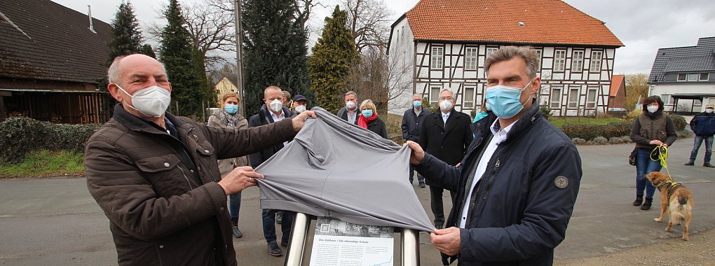 Wissenswertes &uuml;ber das denkmalgesch&uuml;tzte Zollhaus in Erder (im Hintergrund) und zw&ouml;lf weitere sehenswerte Punkte gibt es jetzt auf Infotafeln. Eine enth&uuml;llen Heimatvereinsvorsitzender Andr&eacute; Bierbaum (vorne, von links) und Vlothos B&uuml;rgermeister Rocco Wilken. - &copy; Jens Rademacher