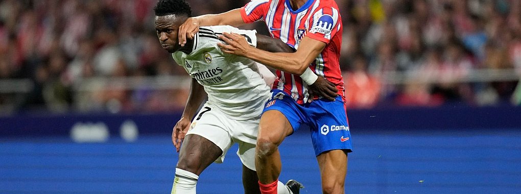 Kämpfen um den Ball und den Sieg im Stadtderby von Madrid: Reals Vinicius Junior (l) und Atleticos Marcos Llorente - © Bernat Armangue/AP