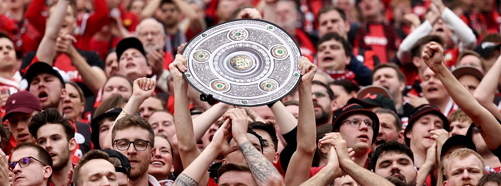 Fu&szlig;ball: Ein Leverkusener Fan h&auml;lt w&auml;hrend des Spiels eine Nachbildung der Meisterschale in den H&auml;nden. Bayer Leverkusen gewinnt die Deutsche Meisterschaft. - &copy; Rolf Vennenbernd/dpa