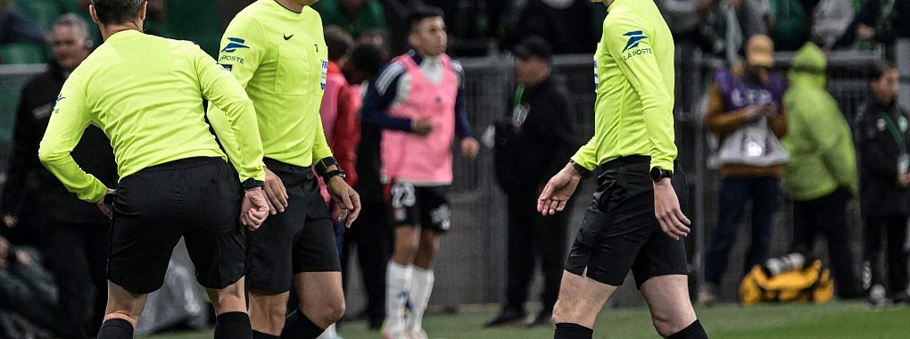 Von einem Gegenstand getroffen: Linienrichter Mehdi Rahmouni (M.), der gl&uuml;cklicherweise unverletzt blieb. - &copy; Jean-Philippe Ksiazek/AFP/dpa