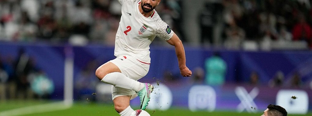 Torschütze Tamer Seyam (r) aus Palästina und Sadegh Moharrami aus Iran im Zweikampf. - © Aijaz Rahi/AP/dpa