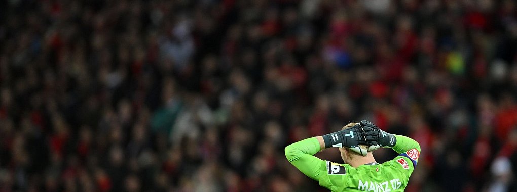 Der Mainzer Torh&uuml;ter Robin Zentner hat einen harmlosen Weitschuss zun&auml;chst durch die H&auml;nde gleiten lassen und sich dann selbst ins Netz geboxt. - &copy; Marius Becker/dpa