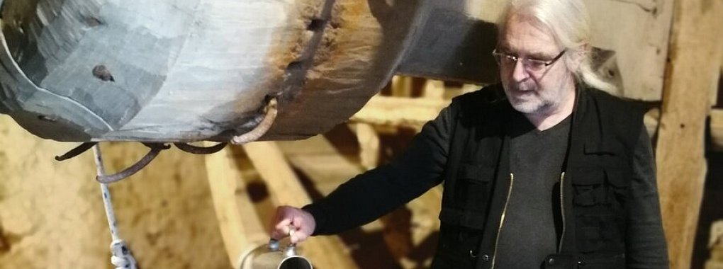 Frank Jendreck von der Kulturagentur des Landesverbandes Lippe, gießt Wasser in den Brunnen und demonstriert damit, wie tief es hinunter geht. - © Freya Köhring