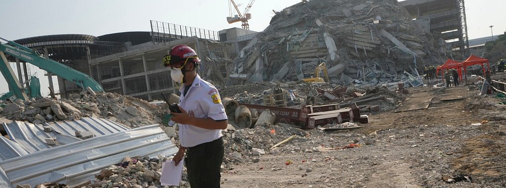 Ein Rettungshelfer geht an der Stelle vorbei, an der ein im Bau befindliches Hochhaus nach einem Erdbeben der Stärke 7,7 zusammengebrochen ist. Ein starkes Beben mit Epizentrum im Nachbarland Myanmar hat die Region in Südostasien erschüttert. - © Sakchai Lalit/AP/dpa-tmn
