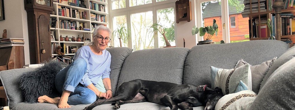 Elisabeth Hartmann mit Windhund „Rosie" auf der Couch im Wohnzimmer. - © Sven Kienscherf