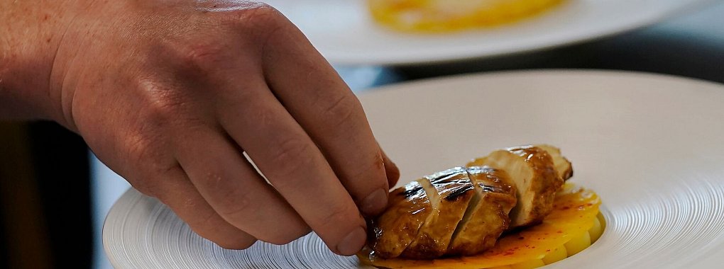 Der Chefkoch Zach Tyndall bereitet das gezüchtete Huhn von Good Meat zu. - © Jeff Chiu/AP/dpa